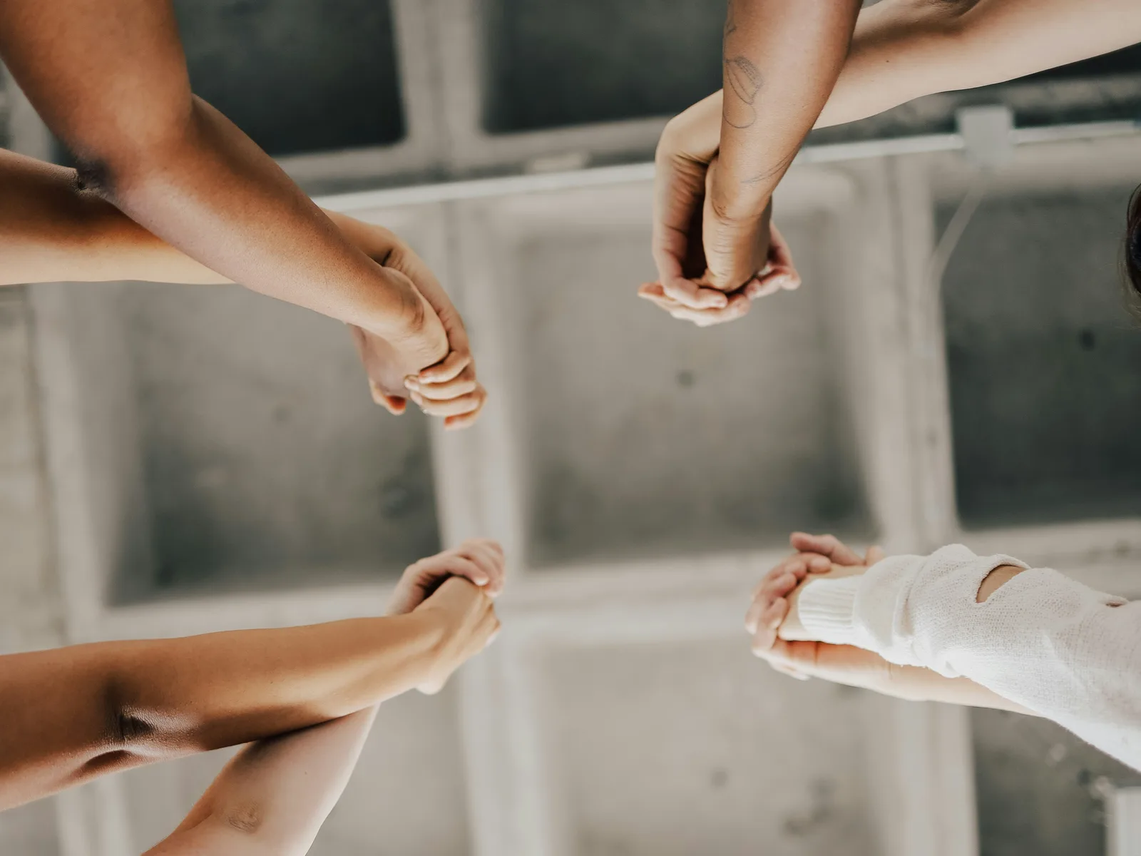Looking up at a circle of women joining hands overhead